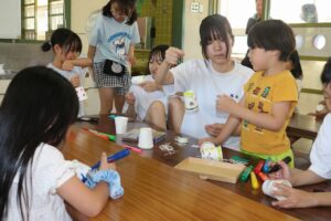 柏原高インターアクト。アフタースクールを利用する子どもたちと風鈴作りを楽しむ部員たち
