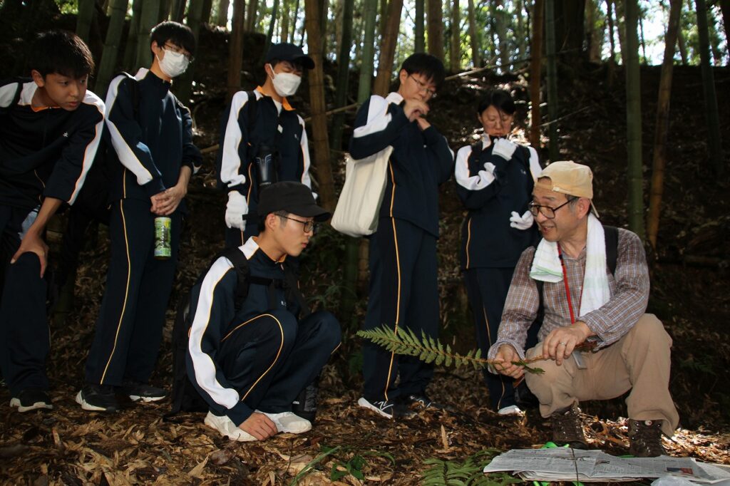 シダ植物の説明を県立人と自然の博物館の鈴木武研究員（右端）から聞く理科部員たち